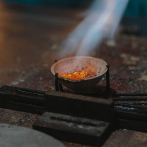 A jeweler working with molten metal to craft unique jewelry pieces.